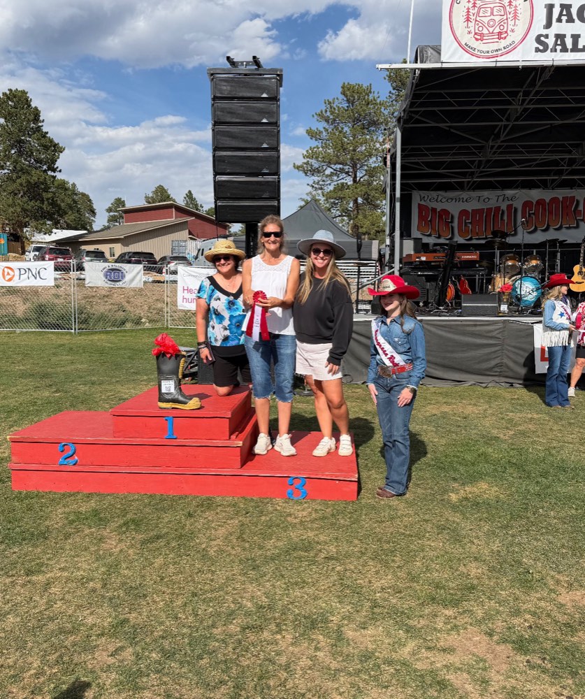 The ECA team standing on the third-place podium in front of the Big Chili Cook-Off stage