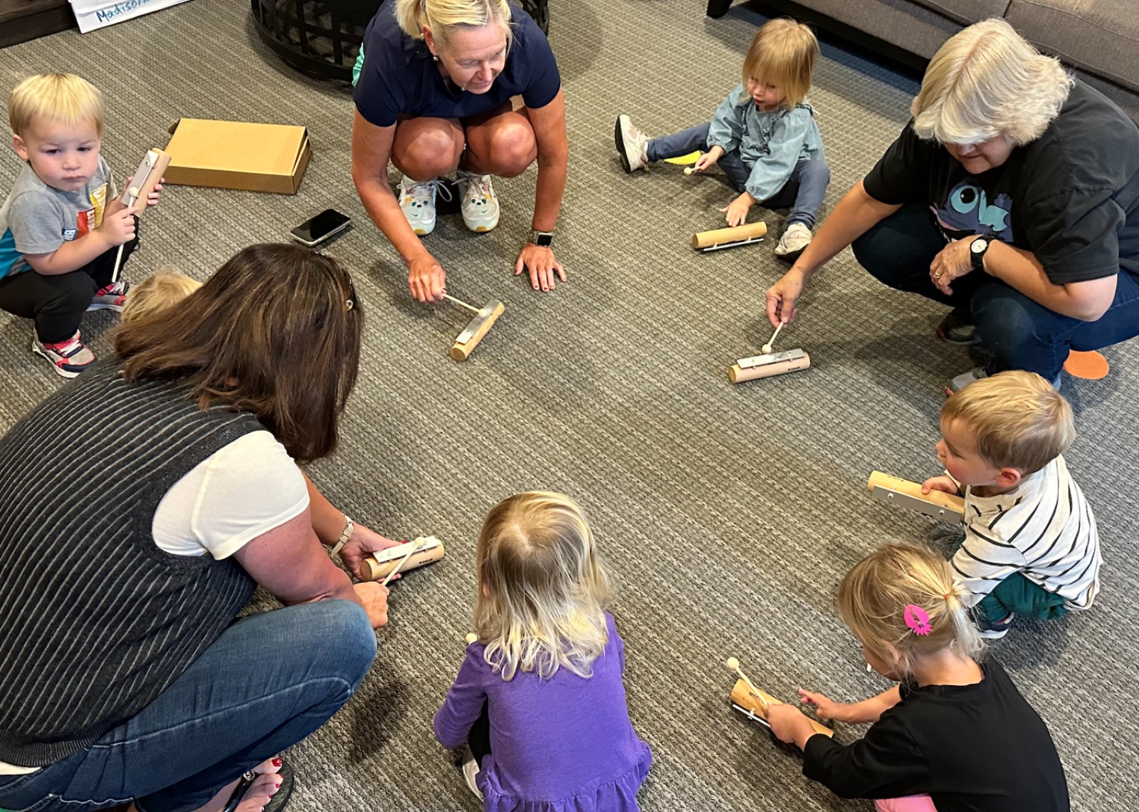 Toddlers playing rhythm instruments in a circle