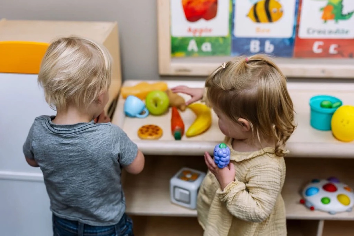 Two toddlers playing with pretend fruit